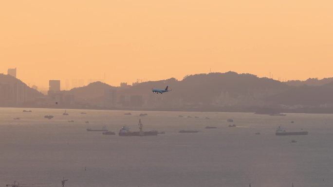 飞机在晚霞中从珠江口降落深圳机场
