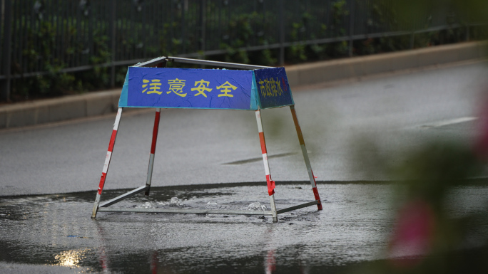 暴雨过后道路上的下水道雨水从井盖上冒出