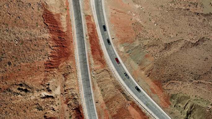 西北戈壁沙漠的公路上行驶的汽车队