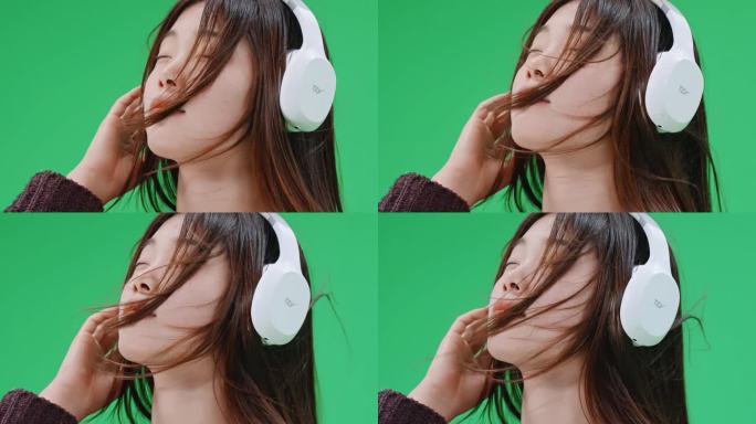 4K绿屏抠像素材 风中戴耳机的女生