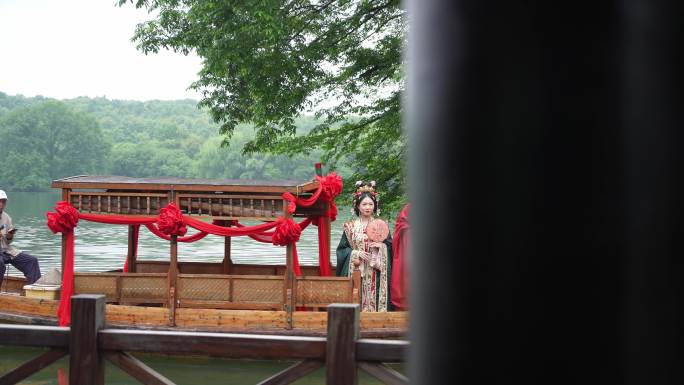 西湖上新郎新娘在手摇船山给中式婚礼