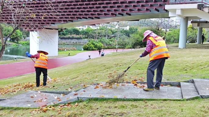 环卫工人保洁员在打扫卫生公园的落叶