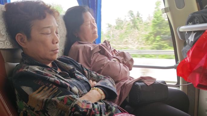 养神休息的乘客睡觉乘客 旅游大巴上乘客疲