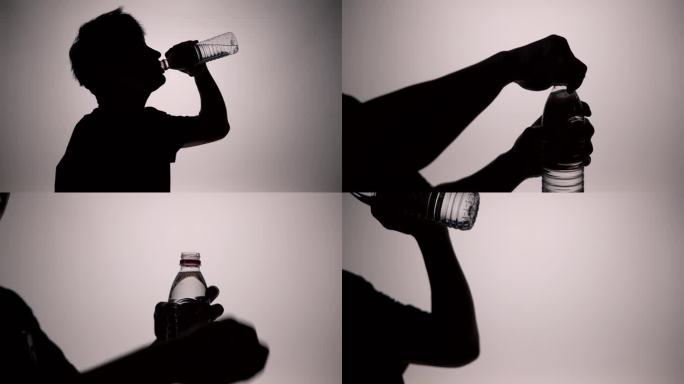 男人喝水剪影男人拧开矿泉水瓶喝水运动喝水