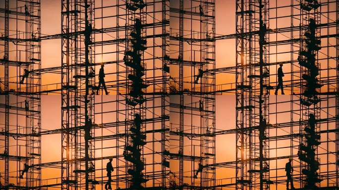 建筑工地工人在日落时分建造摩天大楼