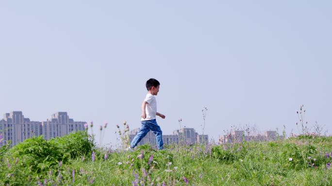 4K小男孩在草地上快乐地奔跑升格慢动作