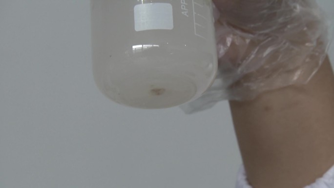 农药实验 加水量杯 到入棕色颗粒剂 搅拌