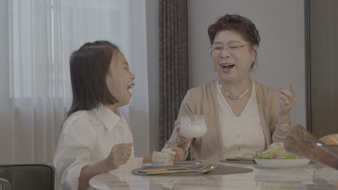 奶奶和孙女吃早餐喝牛奶