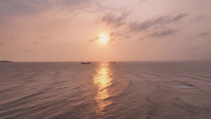 日落倒映在海面 弧形的千层浪泛起金色涟漪