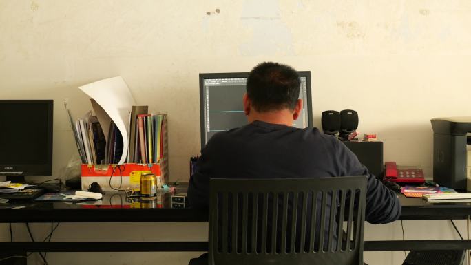 一个中年男人坐在电脑前设计图片