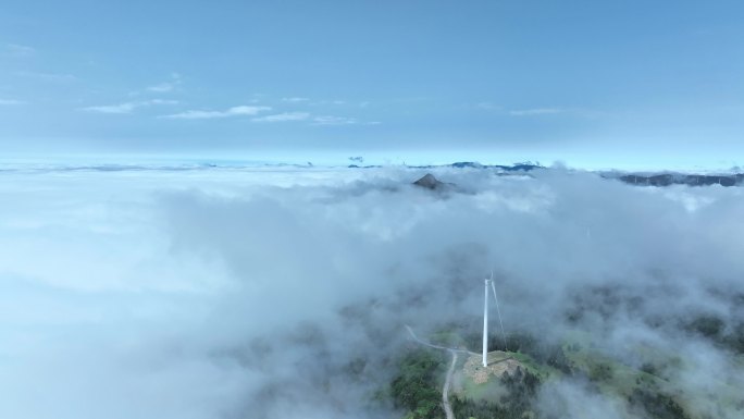 春天阳光下桂林高山上的云雾和风力发电风车