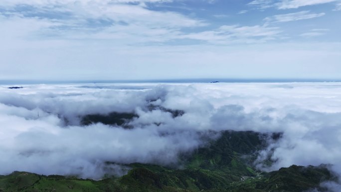 阳光下桂林高山上的风力发电风车和云海