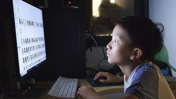 小学生在晚上使用电脑学习