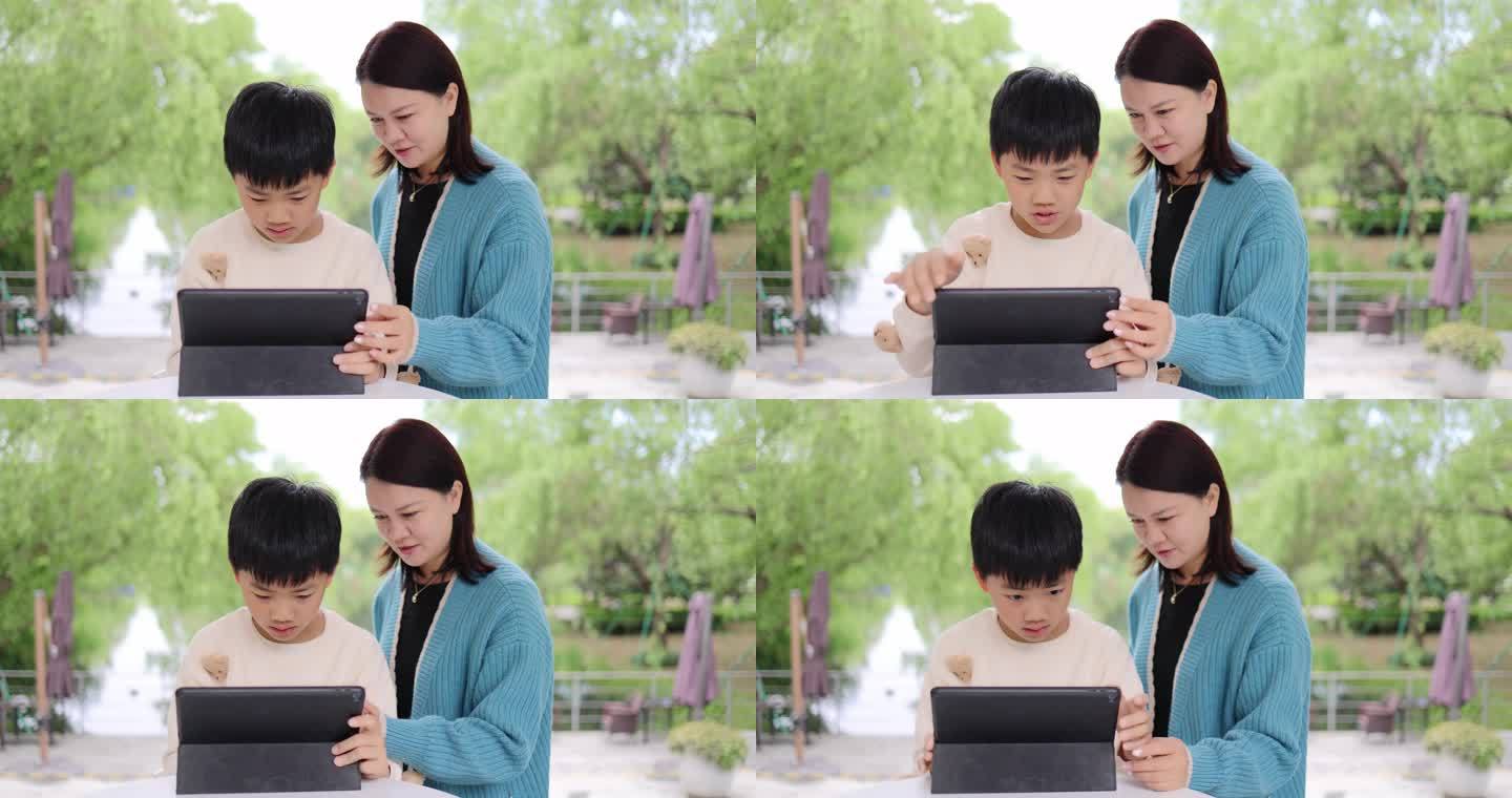 妈妈辅导孩子学习使用平板电脑上网课