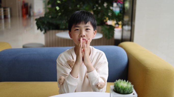 可爱的中国小男孩坐在沙发上鼓掌唯美慢镜