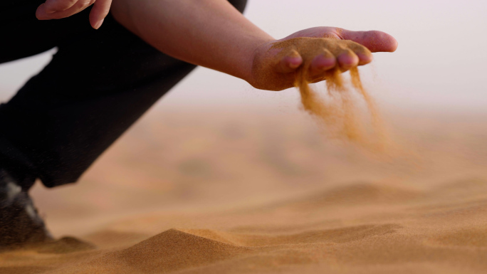 男人在沙漠用手抓起沙子特写