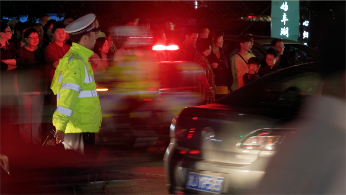 夜间人流高峰，交警在红绿灯前指挥交通
