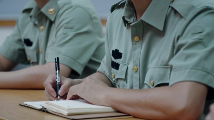 部队开会认真记录学习 做笔记的部队军人