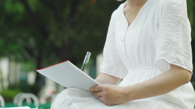 美女在公园拿笔写信记录 写信的女人