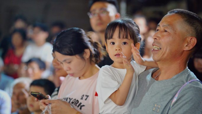 老人抱着小孩开心鼓掌