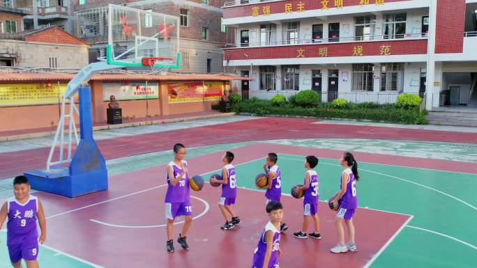 小学生在篮球场训练投篮