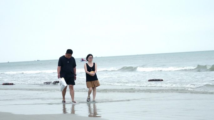 海滩上开心的人们拍照打卡情侣亲子
