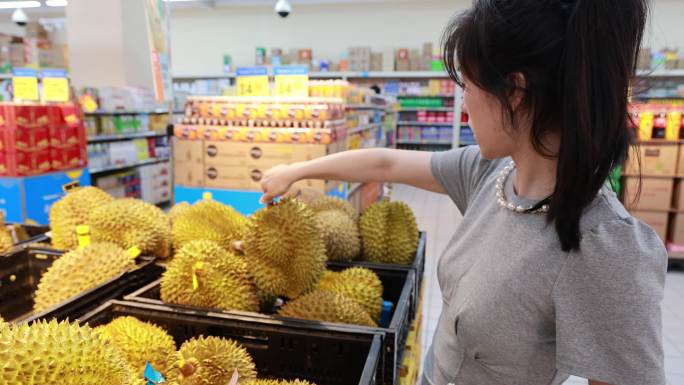 亚洲年轻女子超市购物选购榴莲