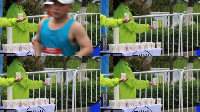 志愿者用手托着水杯等待马拉松运动员拿水杯