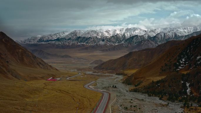 航拍4K新疆甘肃汽车行驶向远方雪山祁连山