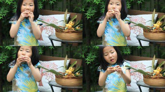 可爱儿童在院子里开心的剥枇杷吃新鲜枇杷