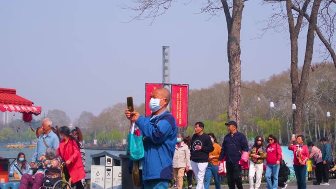 南京玄武区玄武门玄武湖景区游客观赏花朵踏