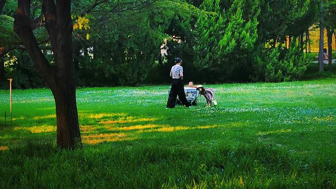 公园草坪上妈妈给小女孩拍照片/亲子游玩