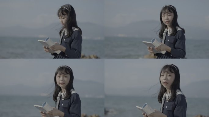 手拿书籍的女学生穿着长裙坐在海边录制MV
