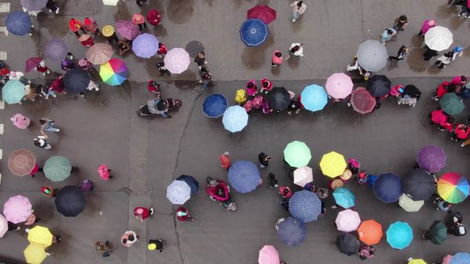 雨天街头撑雨伞看热闹的群众