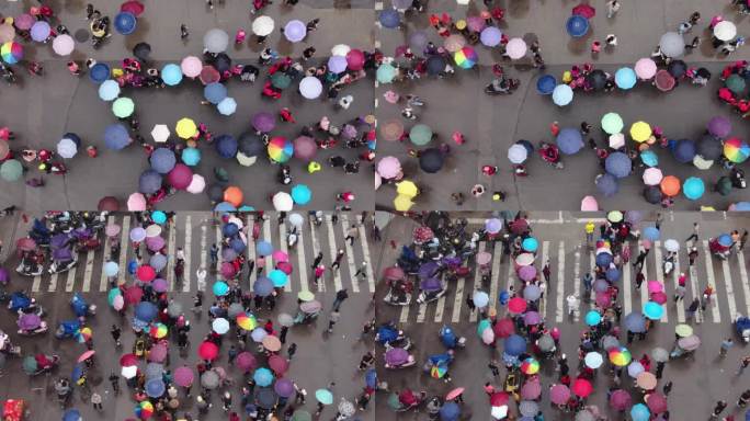 雨天街头撑雨伞看热闹的群众