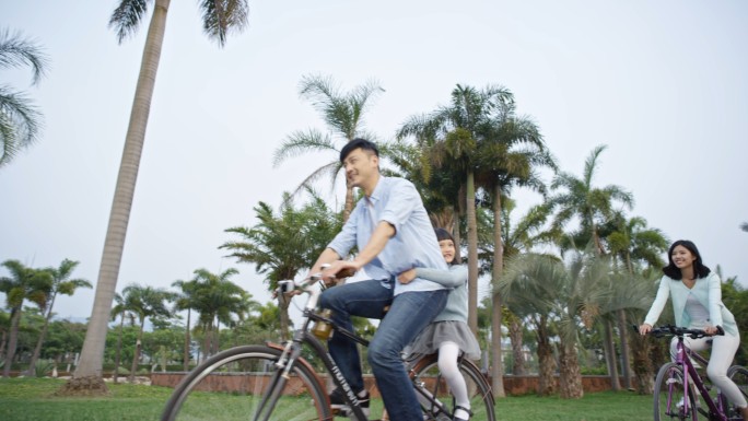 幸福一家三口草地玩耍骑自行车放风筝