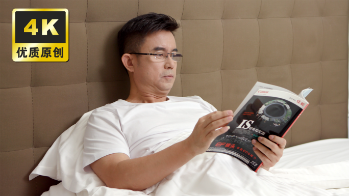 男子在床上看杂志居家看书疲惫揉眼睛困倦