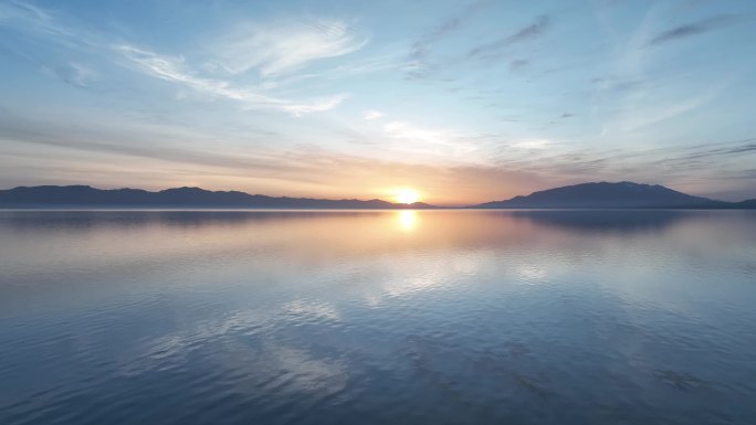 新疆赛里木美丽的日出倒映在平静的湖水上