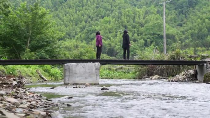 孤独老奶奶走在乡间溪水小桥上守护大山乡村