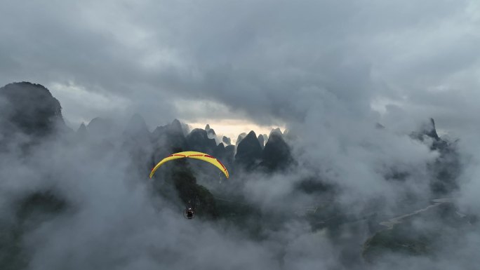 动力滑翔伞在云雾中飞跃桂林山水