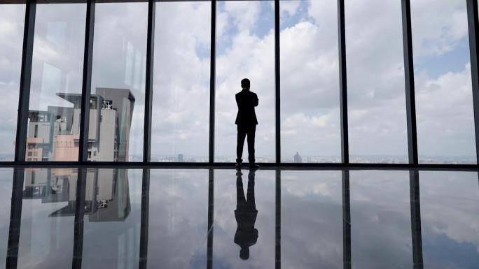 商务成功人士眺望思考背影落地窗