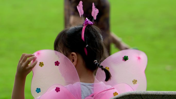 草地上儿童玩耍，戴翅膀的小女孩，玩泡泡