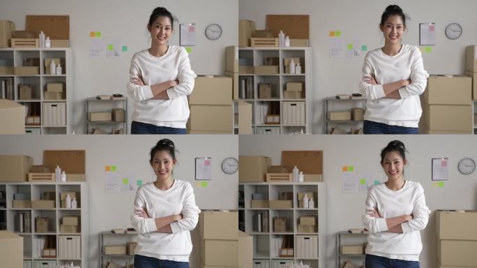 自信的年轻亚洲女性零售商，企业家，在线商店dropshipping小企业主站在配送仓库里拿着包裹箱看