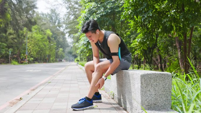 一名亚洲男子小腿抽筋