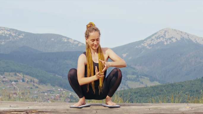 微笑的女人在练瑜伽，在苦修板上冥想。