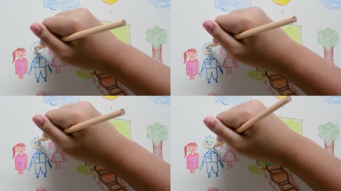 贴近孩子的手，用彩色铅笔在白纸上画画。