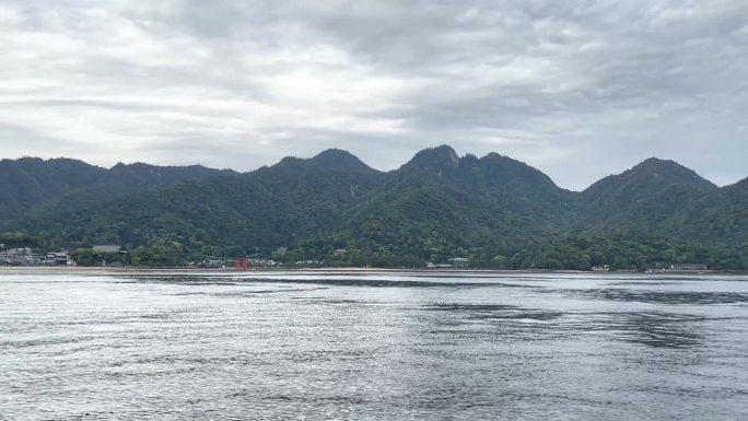 一个美丽的山脉，前景是一个平静的湖泊。伊斯拉的严岛神社。