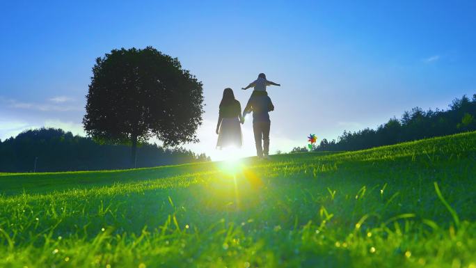 夕阳下爸爸牵着妈妈带着儿子散步-温馨家庭