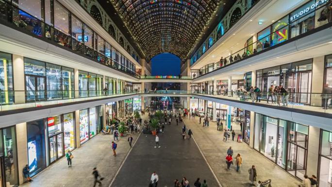 在德国，欧洲柏林市中心的现代购物商场里，顾客和游客在百货商店里逛来逛去
