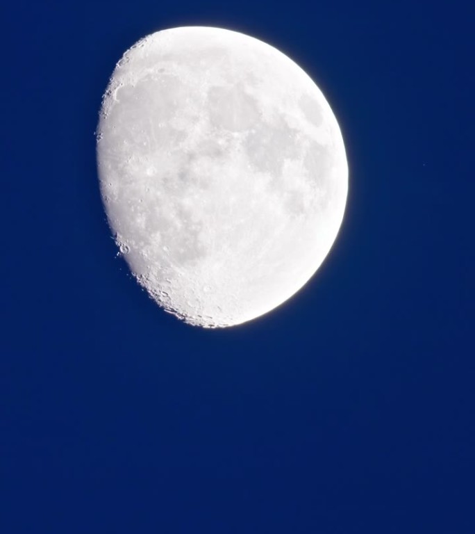 夜晚蔚蓝的天空和皎洁的白月亮划过天空的景色随着时间流逝